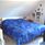 Double bed with blue patterned bedspread in a room with a sloping roof.