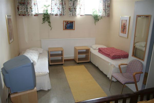 Two single beds in a room in the basement.  