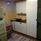 White kitchenette with stove, sink and a green fridge and freezer.