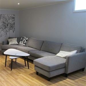Stor grå soffa med soffbord.