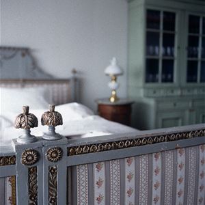 Detail from a grey bedframe with metallic border and upholstered parts. 