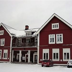 Stort rött tvåvåningshus med vita knutar.