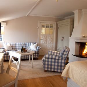 A suite with a double bed and a fire place.