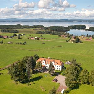 Kungshaga with green fields around and the Lake Orsa behind, taken from above.