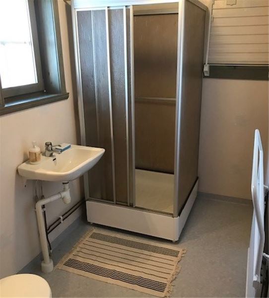 Badrum med duschkabin och tvättställ.  