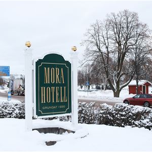 The hotel sign with snow on the top. 