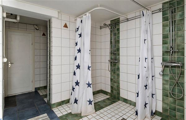 Två duschar med kaklade väggar och golv.  