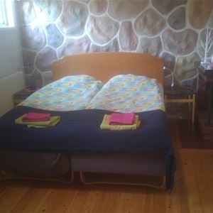 Double bed in a wooden frame in the basement.