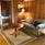Beige soffa med runt bord i ett rum med väggar, golv och tak av furu.