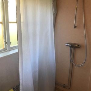 Shower with white shower curtain. 