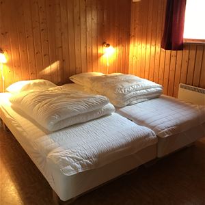 Double bed in a room with pine walls. 