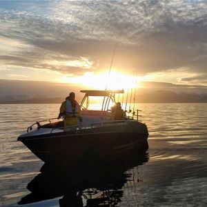  © Jæger Adventure Camp, Boat on the sea, midnight sun in the background