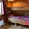 Bunkbed with painted details and a grey and red bedspread.