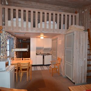 Apartment with refrigerator, microwave, dining table and a loft with beds on.