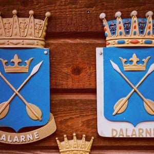 Dalarna landscape weapon with two golden arrows in a cross with blue background.