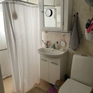 Badrum med dusch, toalett och handfat.