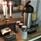 Termoskanna, kaffemuggar och en kandelaber med tända ljus på ett bord.
