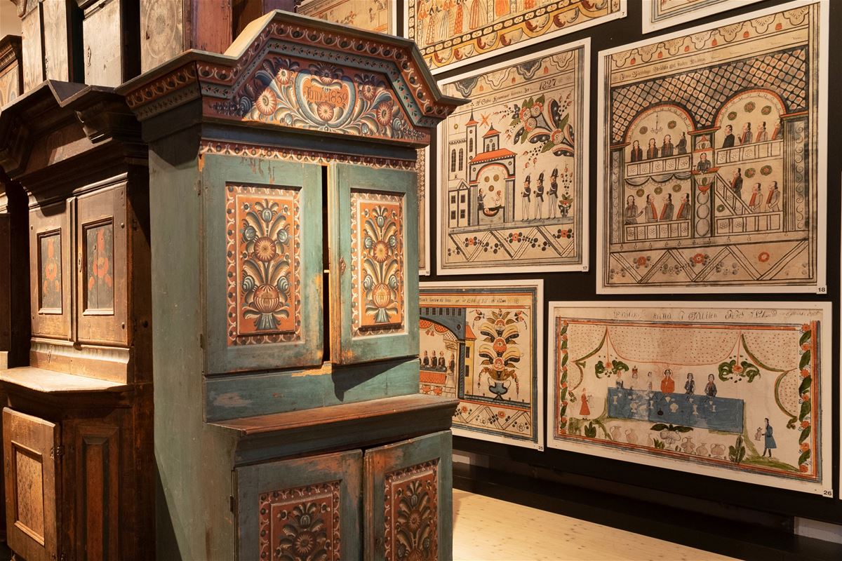 Cabinet and wall paper with Swedish folk paintings.
