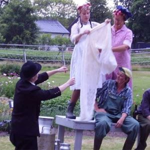 Bild från teaterföreställning, 5 människor vid en mjölkpall.