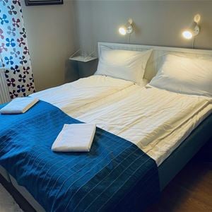 Double bed with dark blue bed cover. 