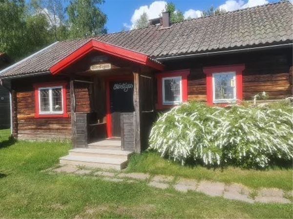 Brown timber cottage with red linings.  