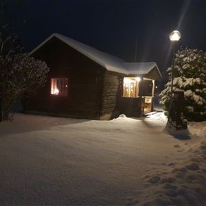 Timbercottage lighted up in the winter darkness. 