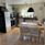Kitchen with dark cupboards and dining furniture for four persons. 
