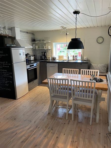 Kitchen with dark cupboards and dining furniture for four persons.  