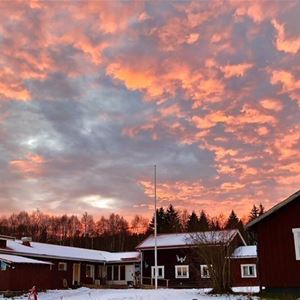 Hornberga Gård med himmel av rosa moln. 