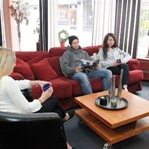 Persons in a sofa group with a cup of coffee in their hands. 