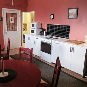 Kitchen with stove, oven, microwave and dining tables. 