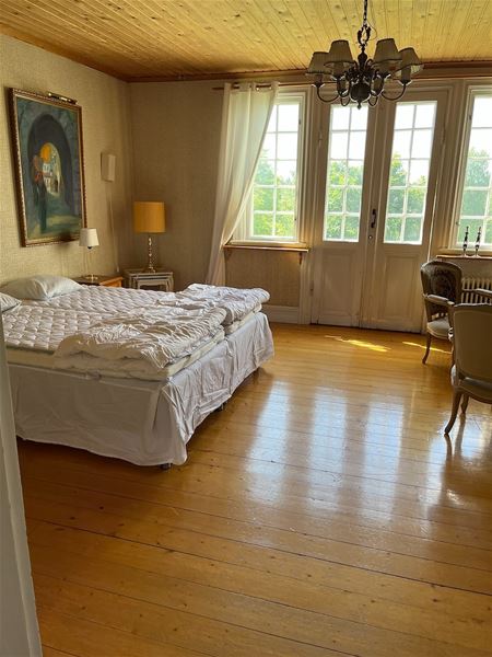 Room with doublebed and large windows.  