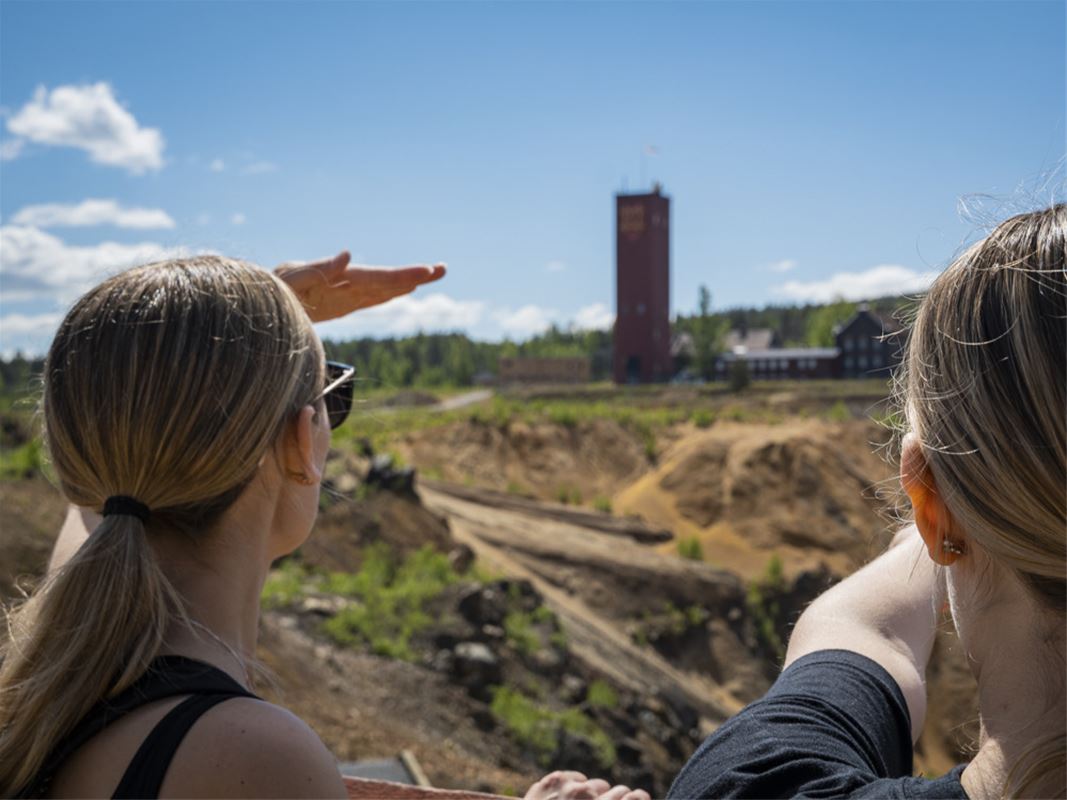 Två personer tittar ut över ett gruvhål.