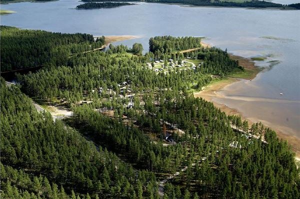Flygbild över campingområdet som ligger alldeles intill sjön. 