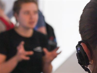 A guide leading the tour and a person with headphones on