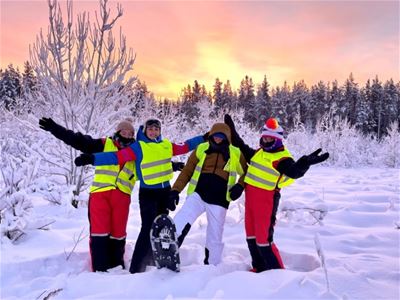 A group of guests play in the snow with snow shoes