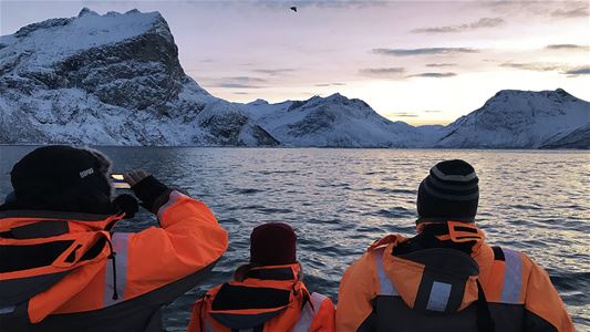 Gjester på en båt som ser fjell og sjøen