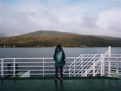 A guest looks out from the ferry to Senja