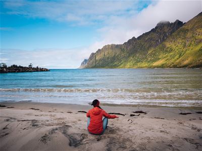 A guest enjoys the moment on one of the sandy beaches on Senja