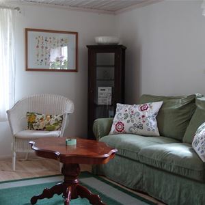 Green sofa and a white armchair and a small round table. 