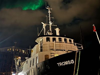 Bilde av båten med nordlyset i bakgrunnen.