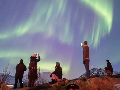 Gjester som ser og tar bilder av nordlyset.
