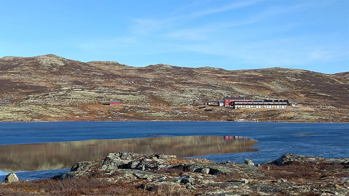 En innsjø med en bygning i bakgrunnen.