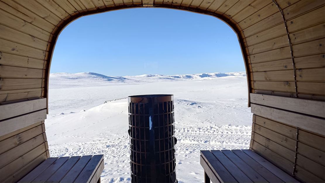 Utsikt over et snødekt landskap fra en trekonstruksjon.
