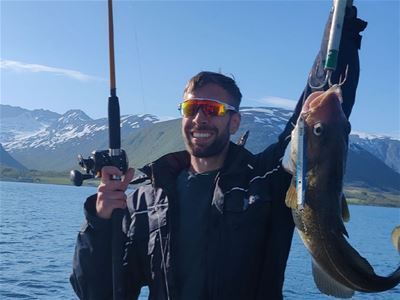 Gjest viser fisk han har fått.