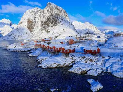 Rorbuer og Snødekte fjell ved kysten