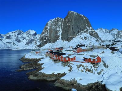 Rorbuer og Snødekte fjell ved kysten