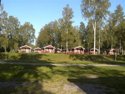 Rödmålade stugor på avstånd.