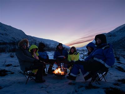 Guests sit by the fire and warm themselves
