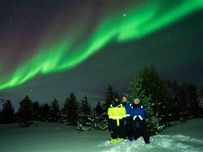 Nordlyset skinner over gjestene mens deres foto blir tatt